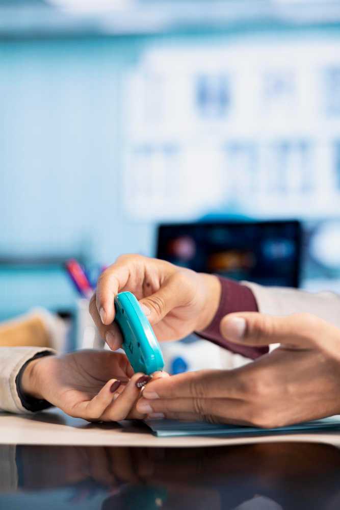 Nurse checking a patient's blood sugar levels in the Diagnostic Department of Prakash Hospital.