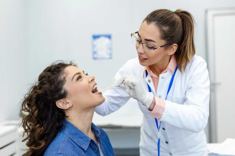 Doctor examining the inside of a patient's mouth in the ENT Department of Prakash Hospital.